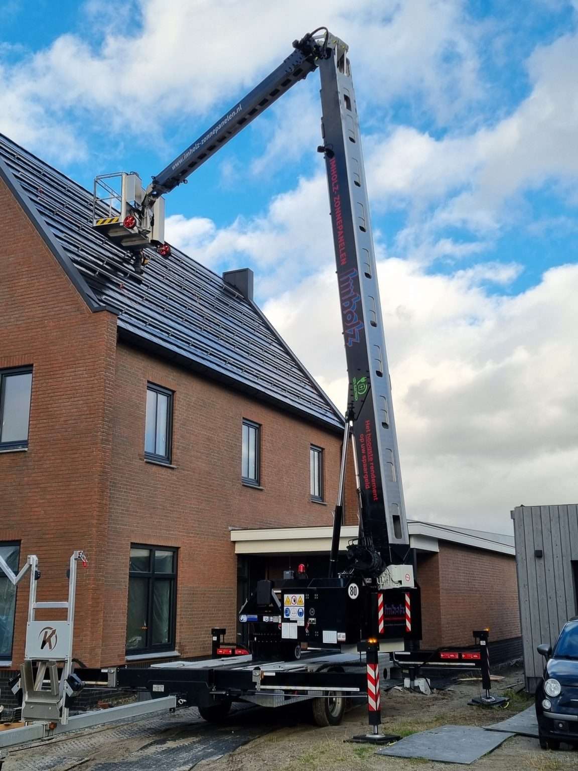 Kraan plaatst zonnepanelen op een woning