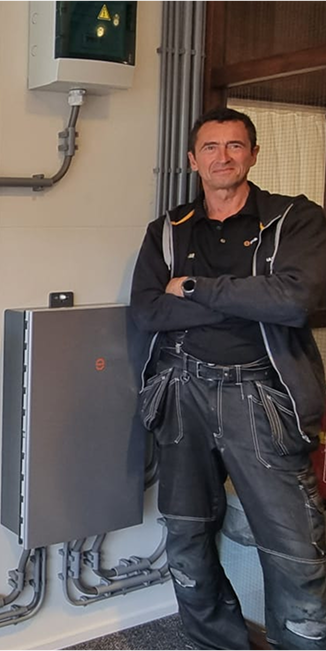 Eigenaar van Imholz Zonnepanelen naast een Enphase thuisaccu